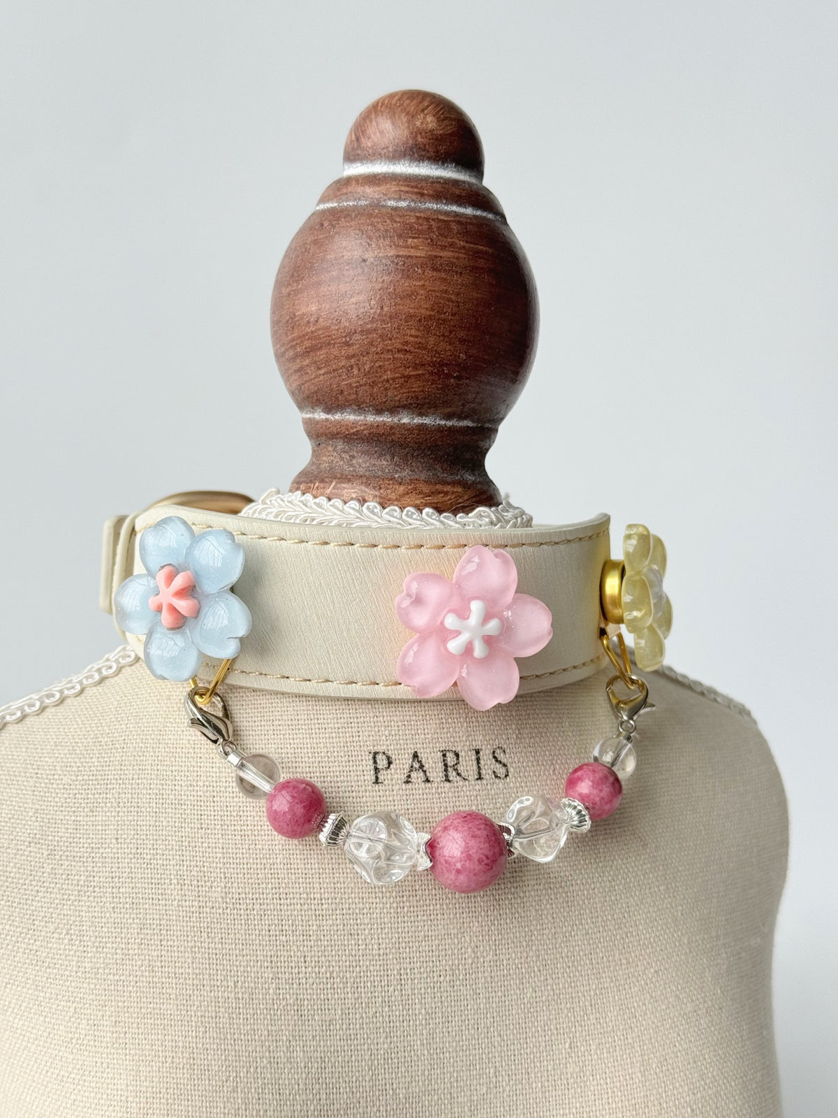 Pawlsle Trails Cherry blossom-themed pet collar set, featuring a beige microfiber leather collar adorned with a detachable, handcrafted chain of beaded gems—a floral-style accessory designed for cats as well as small, medium, and large dogs.