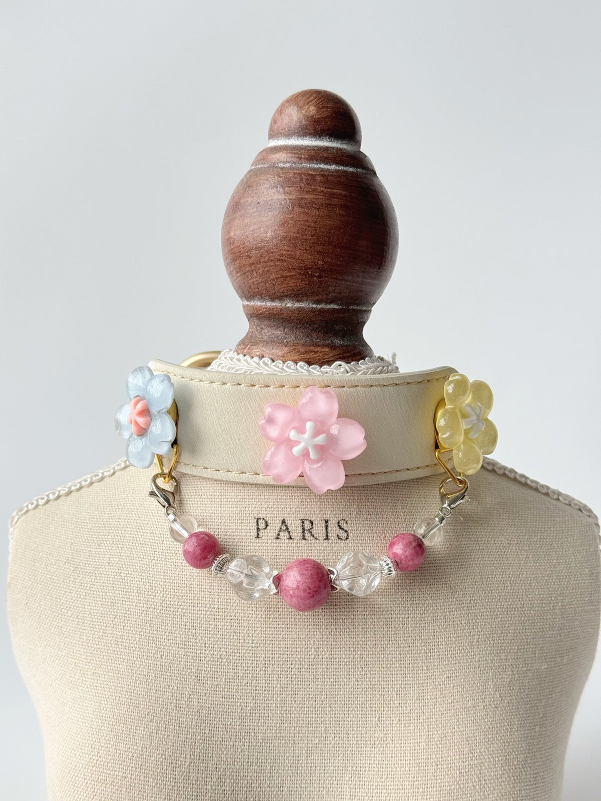 Pawlsle Trails Cherry blossom-themed pet collar set, featuring a beige microfiber leather collar adorned with a detachable, handcrafted chain of beaded gems—a floral-style accessory designed for cats as well as small, medium, and large dogs.