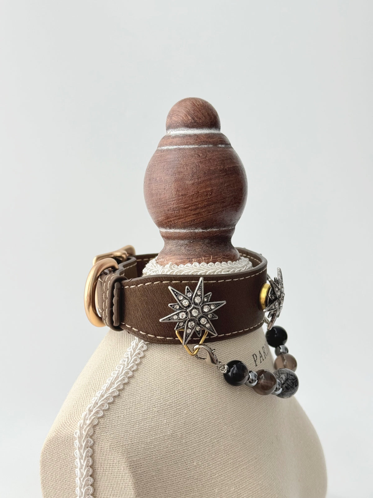 Pawlsle Trails "North Star" jeweled pet collar, crafted from brown microfiber leather and adorned with a rhinestone North Star emblem; features an interchangeable, hand-beaded gemstone chain. Suitable for cats as well as medium-to-large dogs.