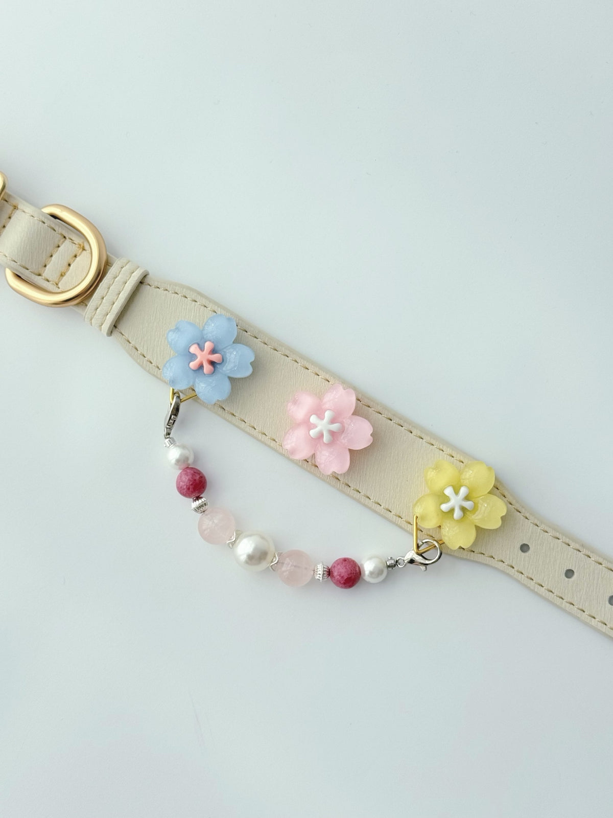 Pawlsle Trails Cherry blossom-themed pet collar set, featuring a beige microfiber leather collar adorned with a detachable, handcrafted chain of beaded gems—a floral-style accessory designed for cats as well as small, medium, and large dogs.