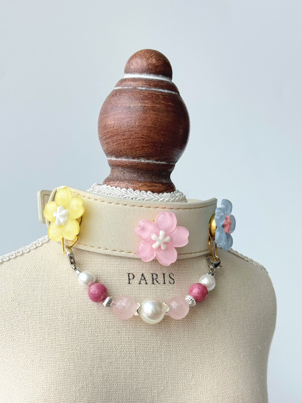 Pawlsle Trails Cherry blossom-themed pet collar set, featuring a beige microfiber leather collar adorned with a detachable, handcrafted chain of beaded gems—a floral-style accessory designed for cats as well as small, medium, and large dogs.