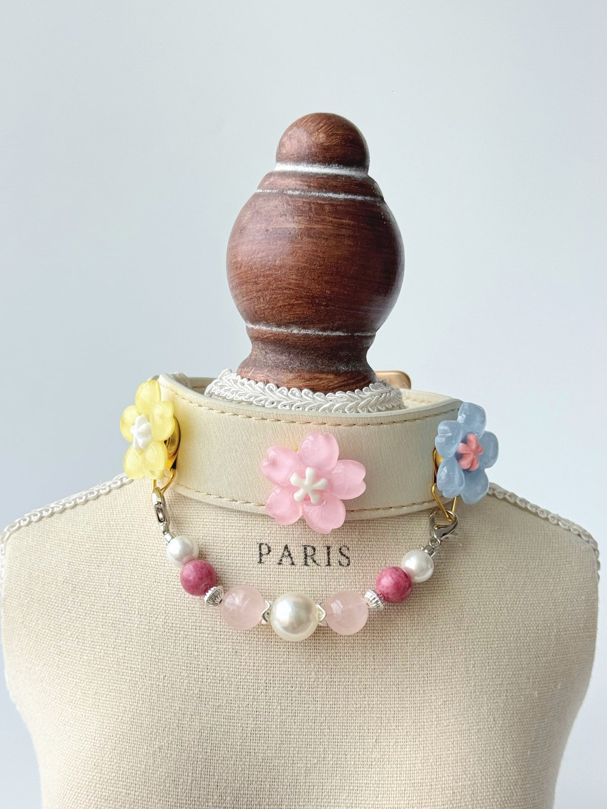 Pawlsle Trails Cherry blossom-themed pet collar set, featuring a beige microfiber leather collar adorned with a detachable, handcrafted chain of beaded gems—a floral-style accessory designed for cats as well as small, medium, and large dogs.
