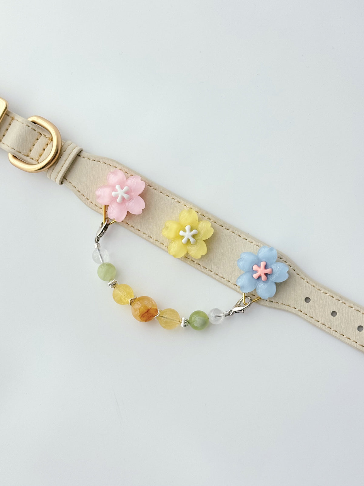 Pawlsle Trails Cherry blossom-themed pet collar set, featuring a beige microfiber leather collar adorned with a detachable, handcrafted chain of beaded gems—a floral-style accessory designed for cats as well as small, medium, and large dogs.