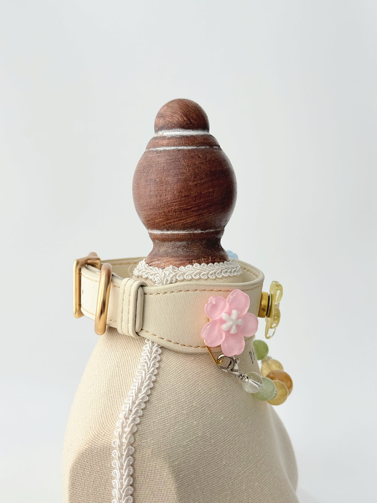 Pawlsle Trails Cherry blossom-themed pet collar set, featuring a beige microfiber leather collar adorned with a detachable, handcrafted chain of beaded gems—a floral-style accessory designed for cats as well as small, medium, and large dogs.