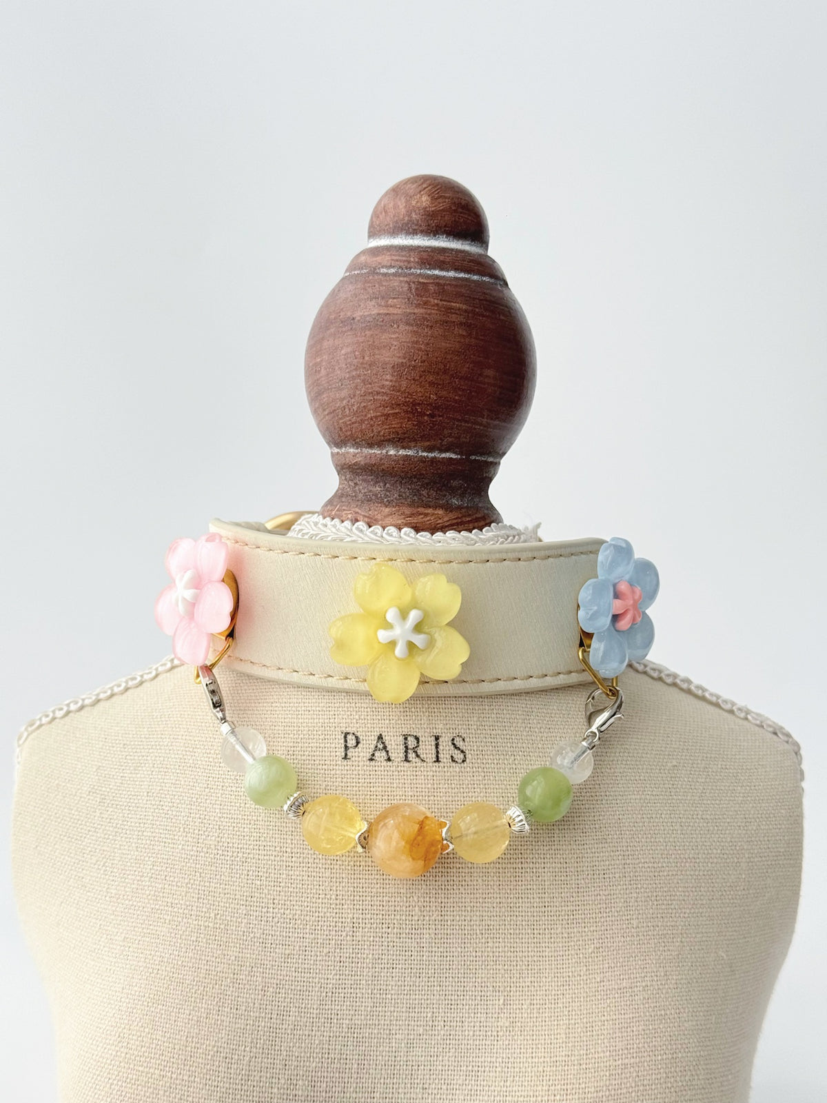 Pawlsle Trails Cherry blossom-themed pet collar set, featuring a beige microfiber leather collar adorned with a detachable, handcrafted chain of beaded gems—a floral-style accessory designed for cats as well as small, medium, and large dogs.